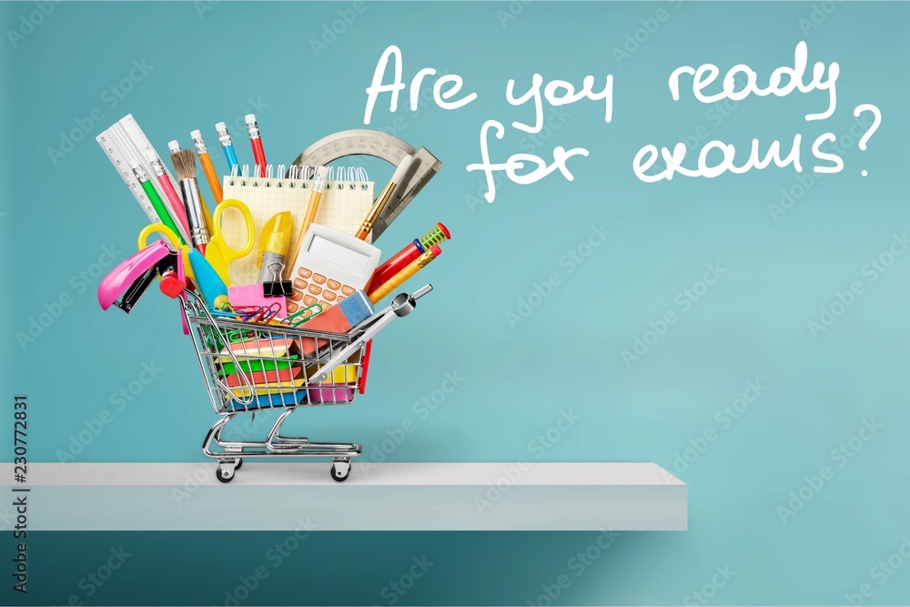 Stationery objects in mini supermarket cart on  background