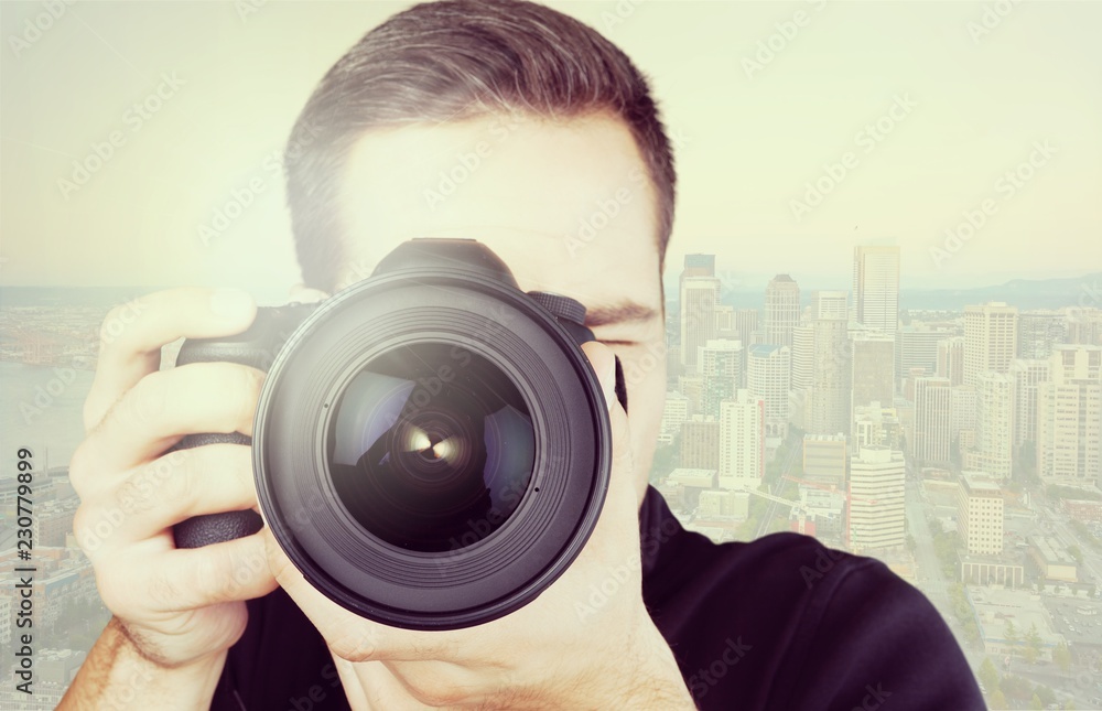 Young male photographer looking through camera