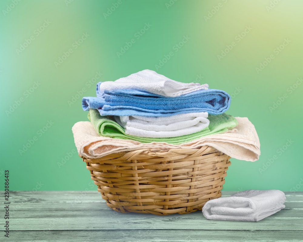 Laundry Basket with colorful towels on background