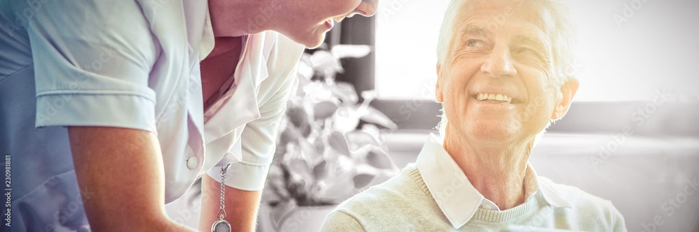 Female nurse showing medical report to senior man on digital