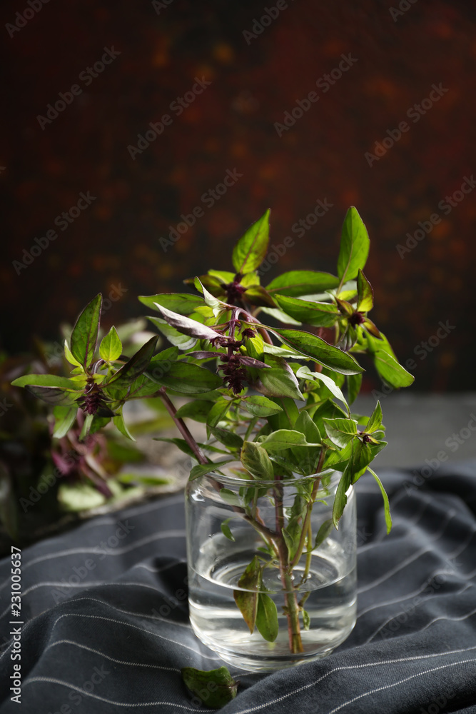 Jar with fresh aromatic basil on table