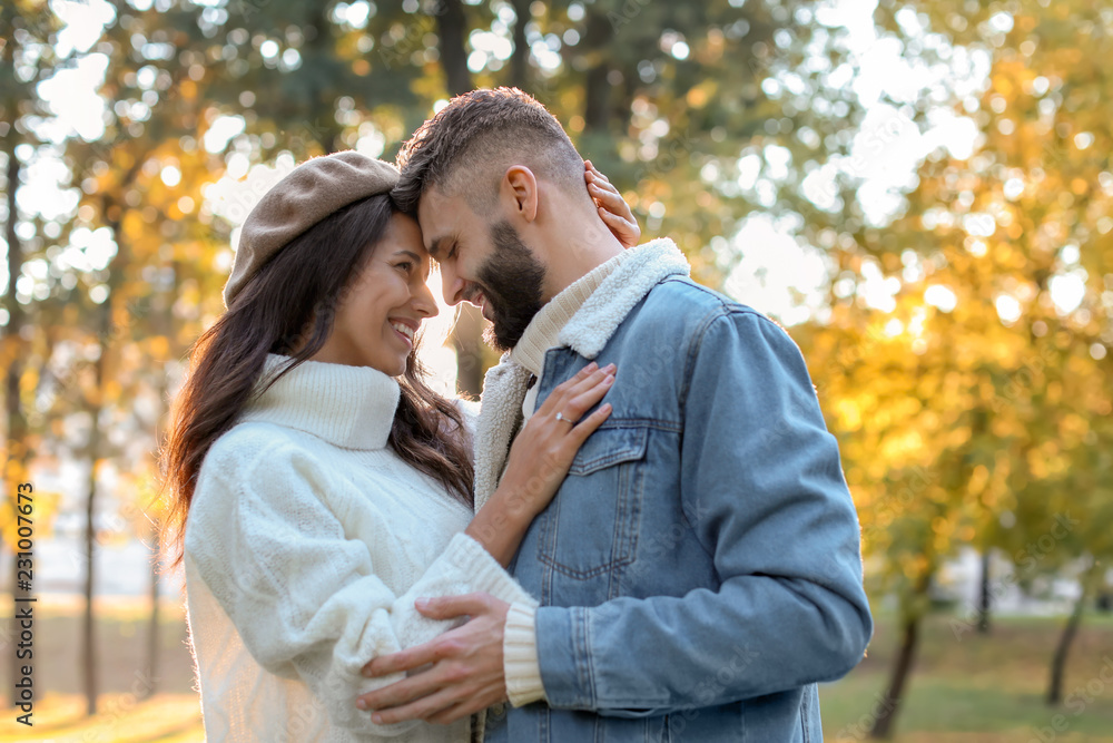 年轻人和情侣在秋季公园戴订婚戒指