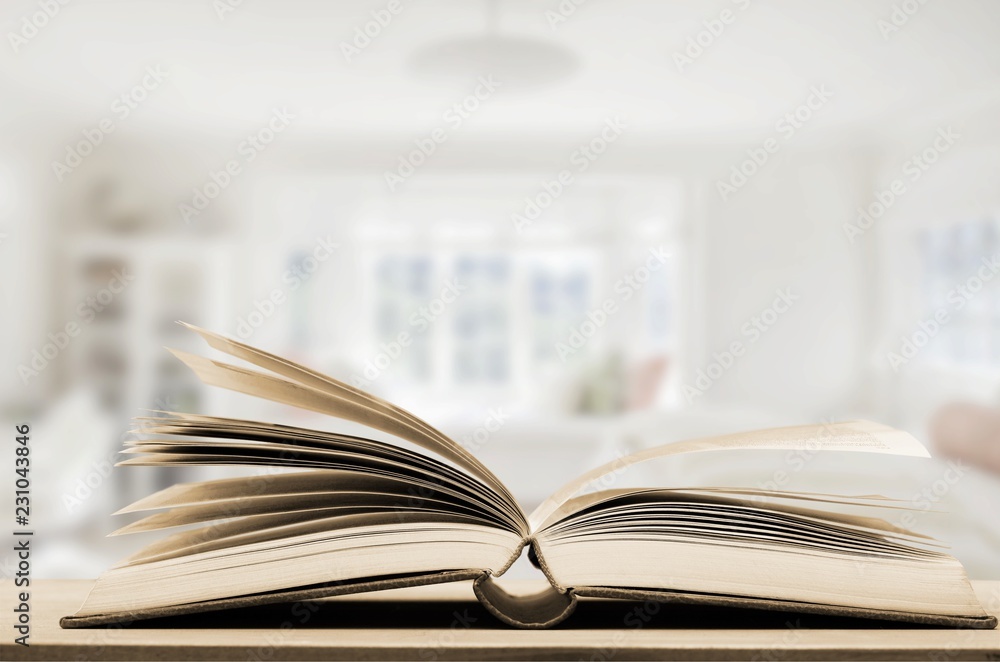 Open book on old wooden table.