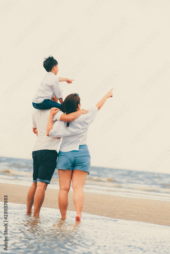 Happy family of father, mother and son goes vacation on a tropical sand beach in summer.