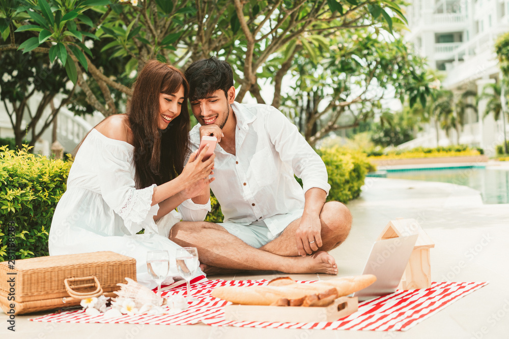 Happy young couple go picnic and dating at the park in summer.