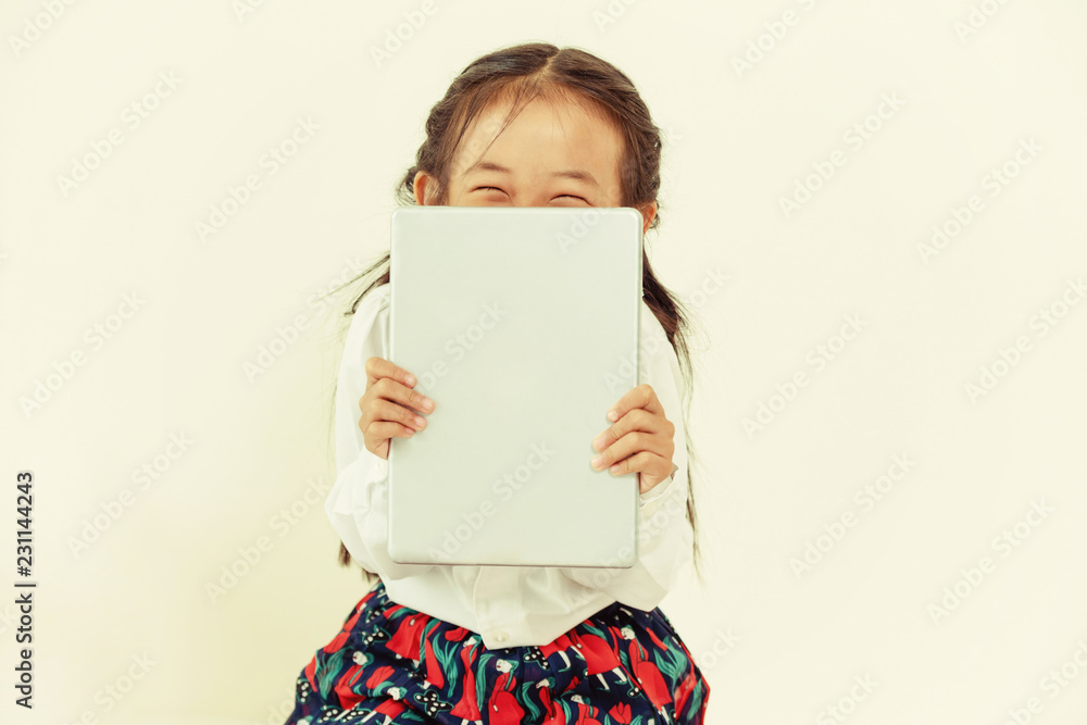 Little happy kid on white background with tablet computer. Childhood lifestyle.