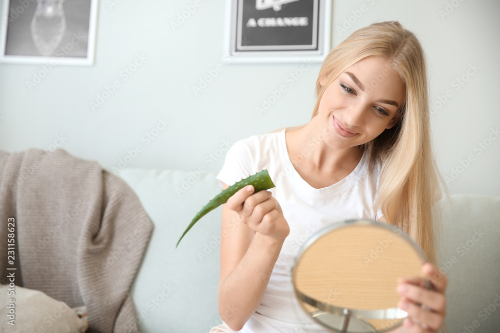 Beautiful young woman using aloe vera at home