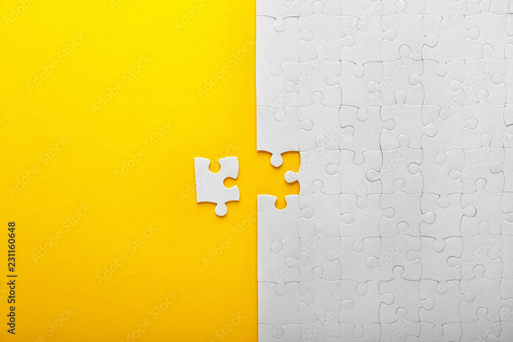 White jigsaw puzzle with piece on color background