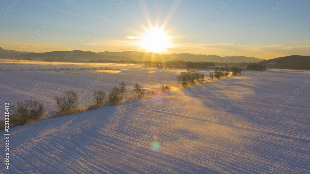 透镜闪光：在一个阳光明媚的冬天早晨，从雪地里升起的薄雾。