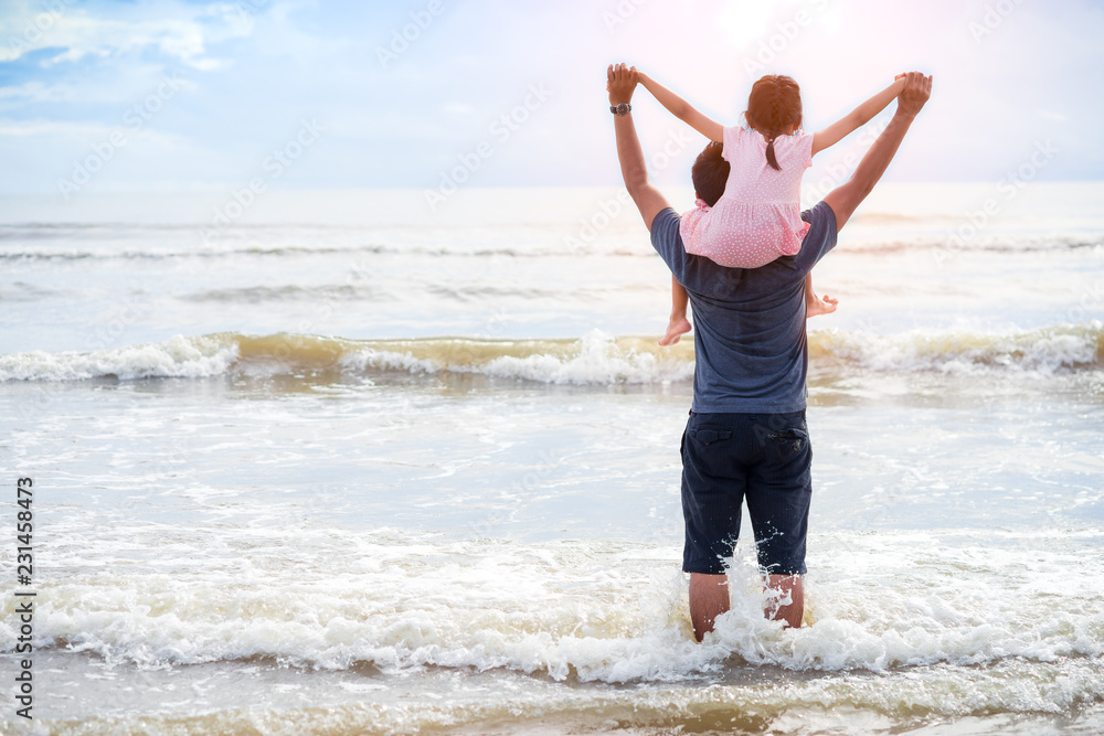 Daughter riding father neck on the beach.Family concept