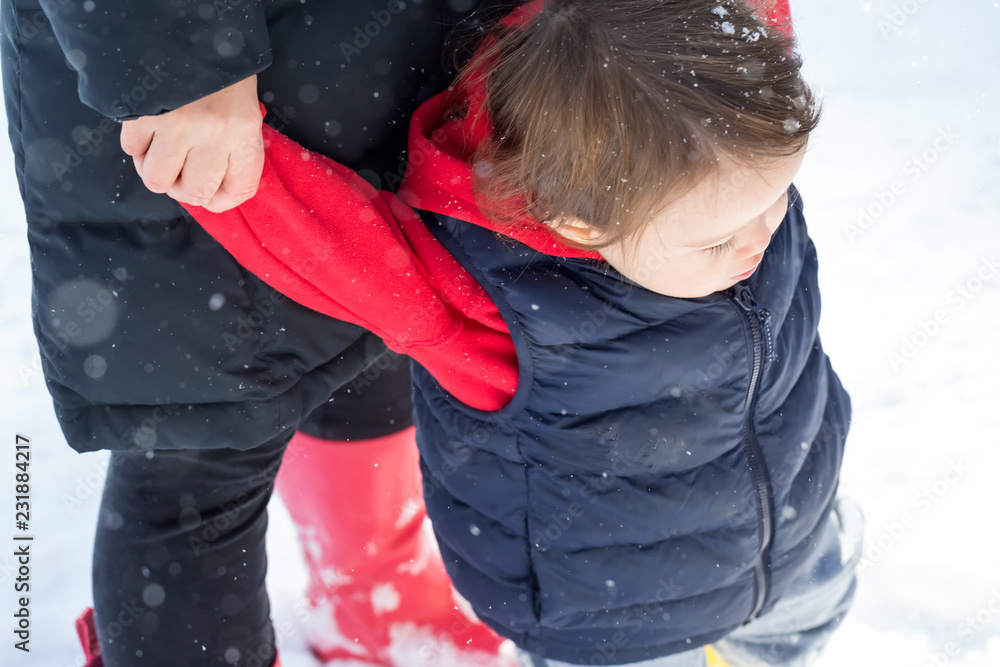 蹒跚学步的男孩和妈妈在雪地里玩耍