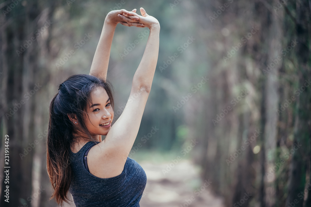 亚洲女孩周末在一片郁郁葱葱的松林里锻炼。运动女孩和李娜