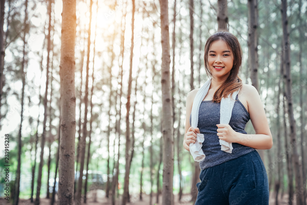 Asian girl is exercising at the weekend in a pine forest green and lush beautiful. Sport girl and li