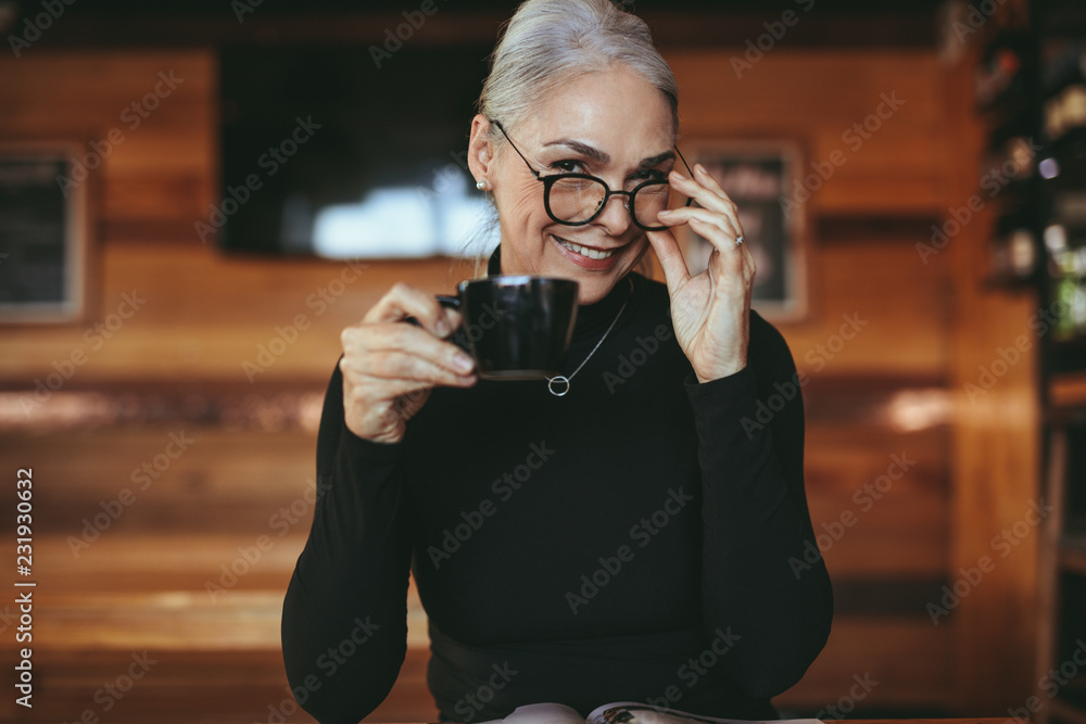 魅力四射的资深女性在咖啡馆喝咖啡