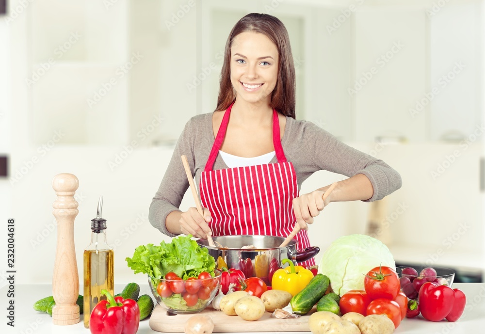 年轻漂亮女人在厨房做饭