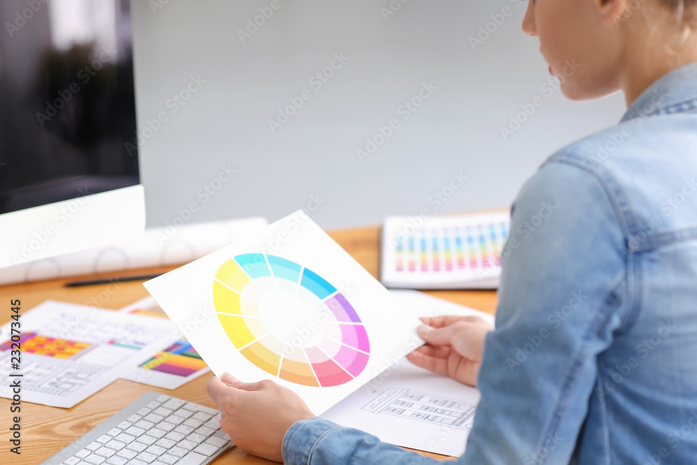 Beautiful young designer working with color palette in office