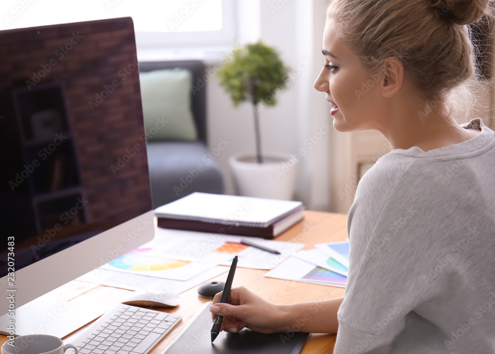 Beautiful young designer working in office