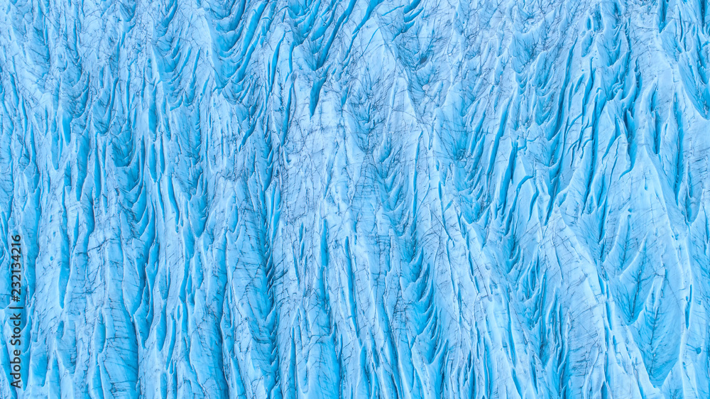 Beautiful glaciers flow through the mountains in Iceland. Aerial view and top view.