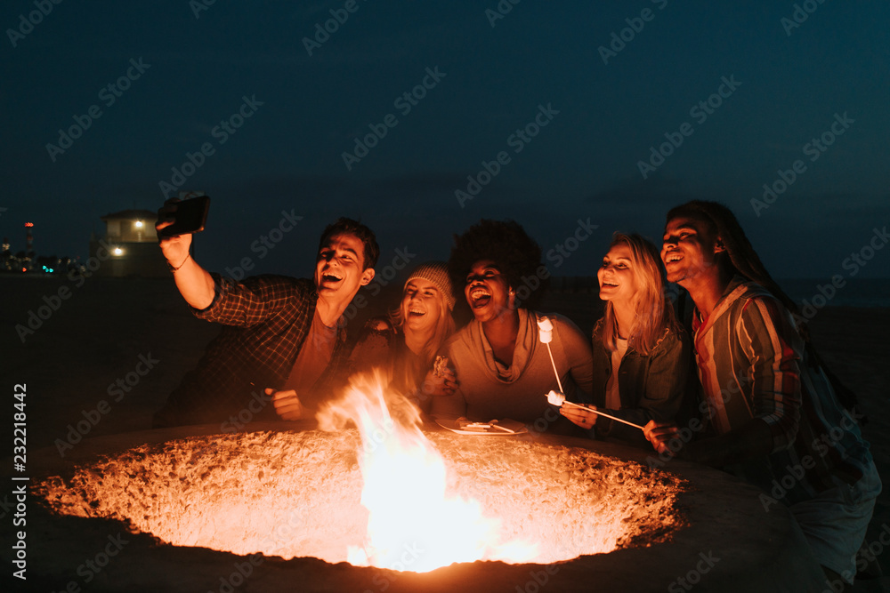 Friends roasting marshmallows over a bonfire