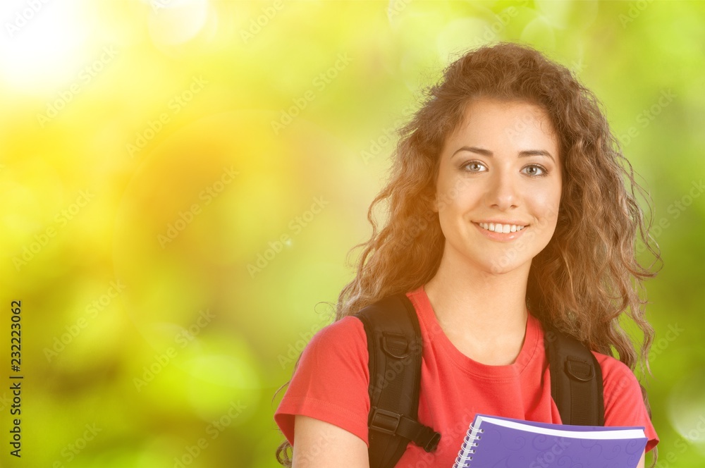 图书馆里带笔记本的漂亮女学生