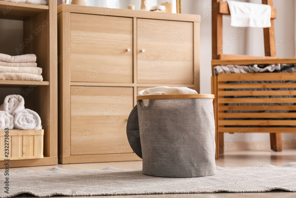 Laundry basket with dirty towels on floor in bathroom