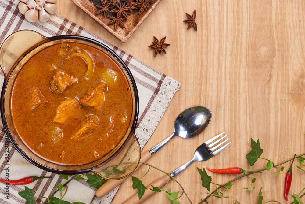 Chicken curry with spice on wooden background