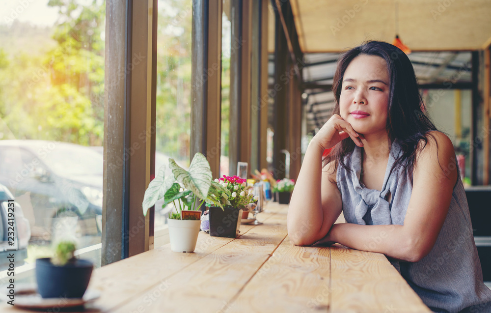 年轻的亚洲美女，夏天坐在咖啡店里。