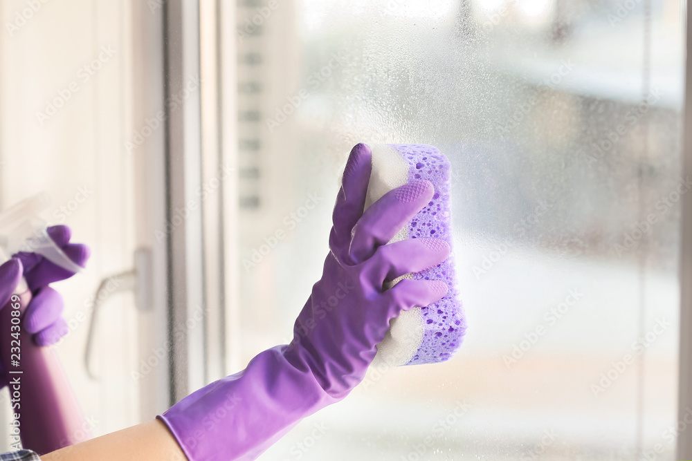 Woman cleaning window at home