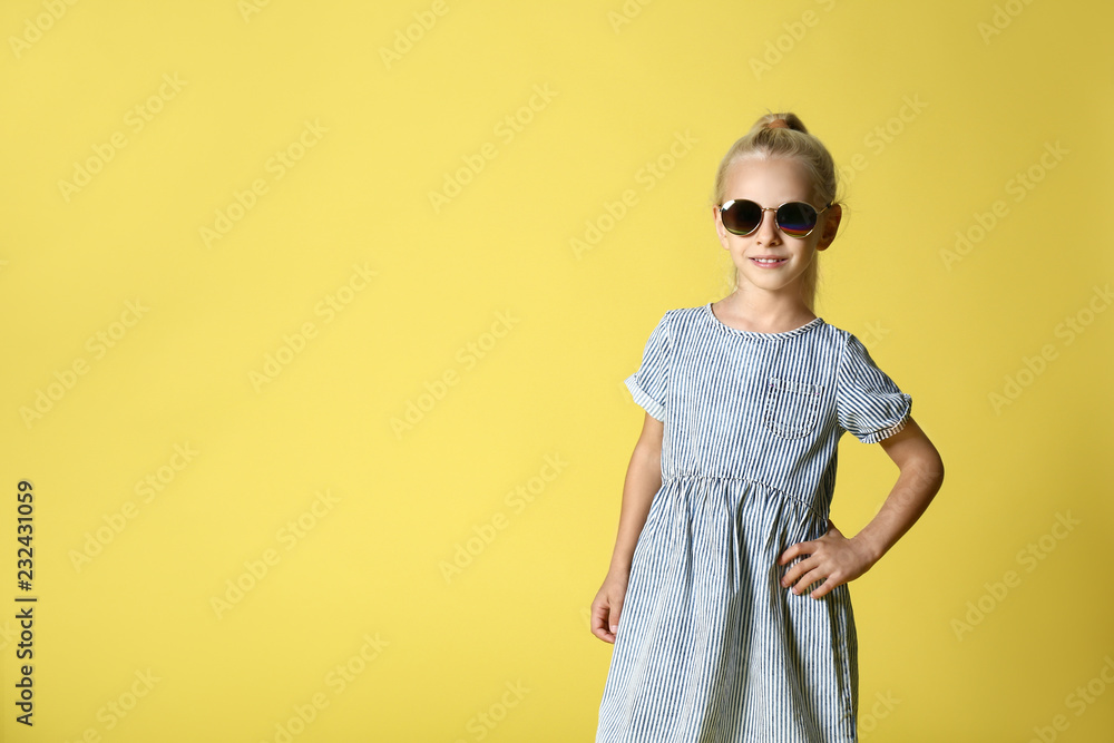 Cute girl in fashionable clothes on color background