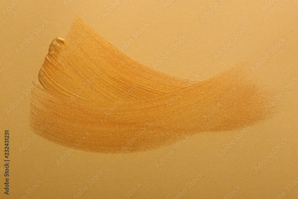 Strokes of gold paint on color background