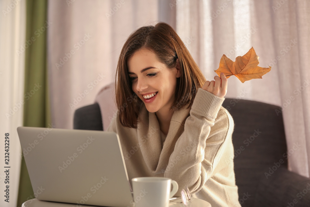 漂亮的年轻女人在家里用笔记本电脑