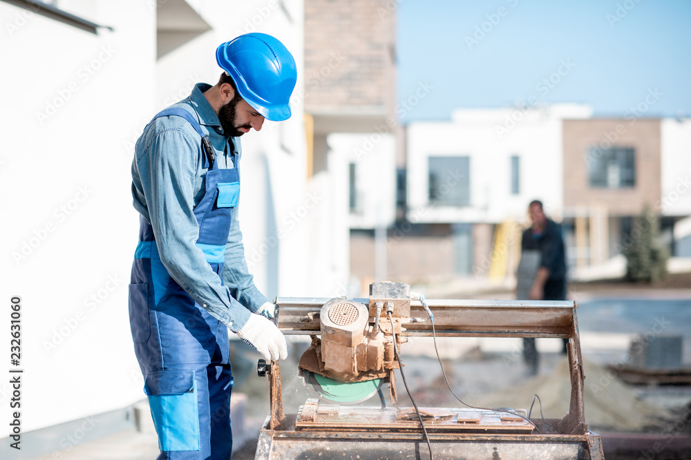 户外施工现场用大电锯均匀切割瓷砖的建设者