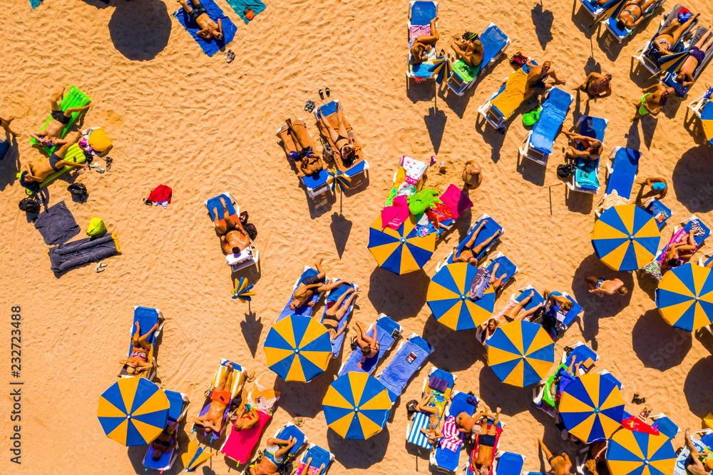 July 10, 2018. Amadores beach, Gran Canaria, Spain. People lying on the beach under the sun. Sunbeds