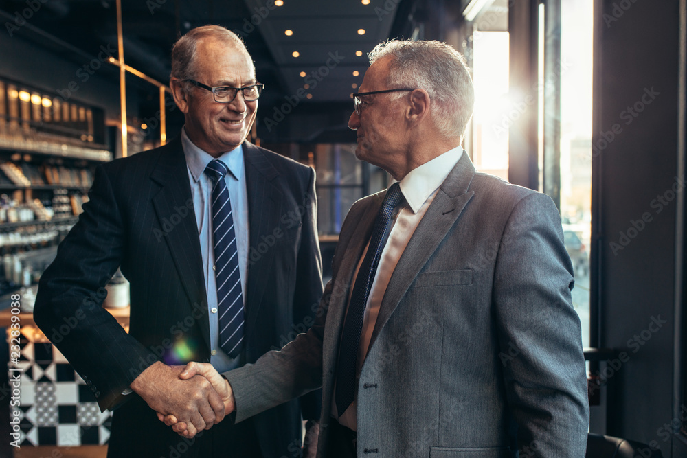 Business partners handshake at cafe