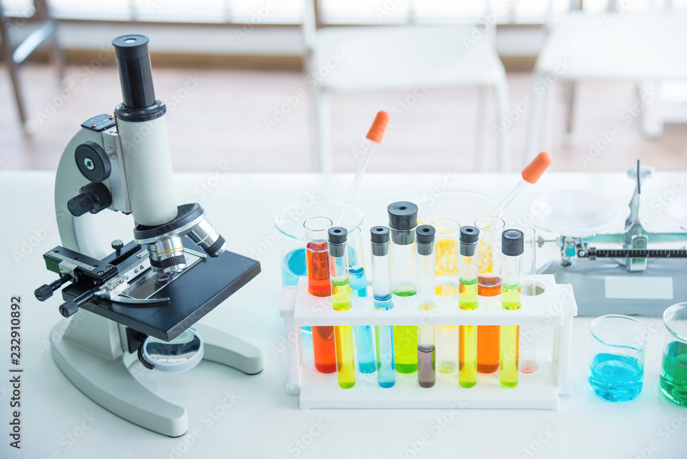 Microscope with many test tubes in the laboratory