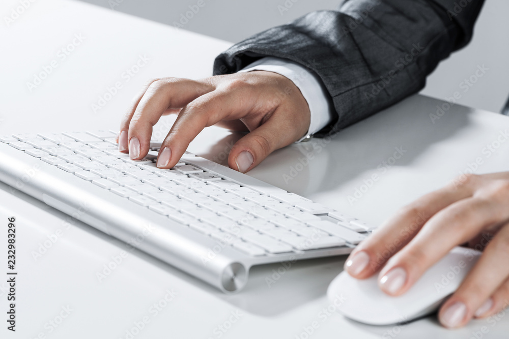 Closeup of businesswoman hand typing on keyboard with mouse on w