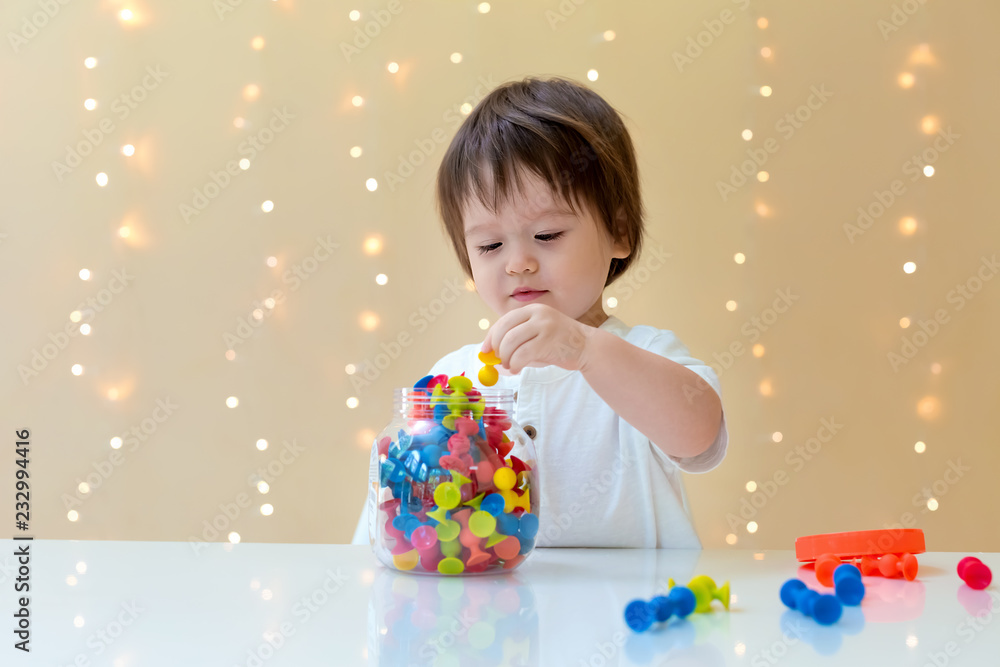 Happy little toddler boy playing with his toys