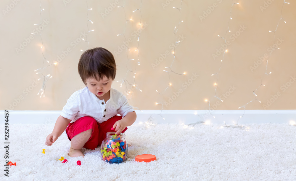 Little toddler boy playing with his toys