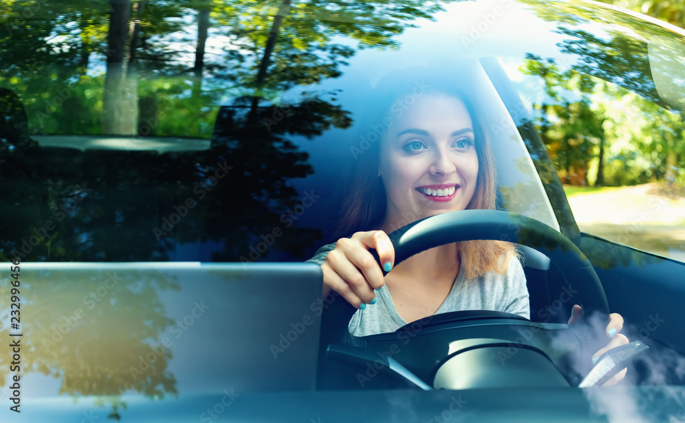 Young woman driving a new luxury car