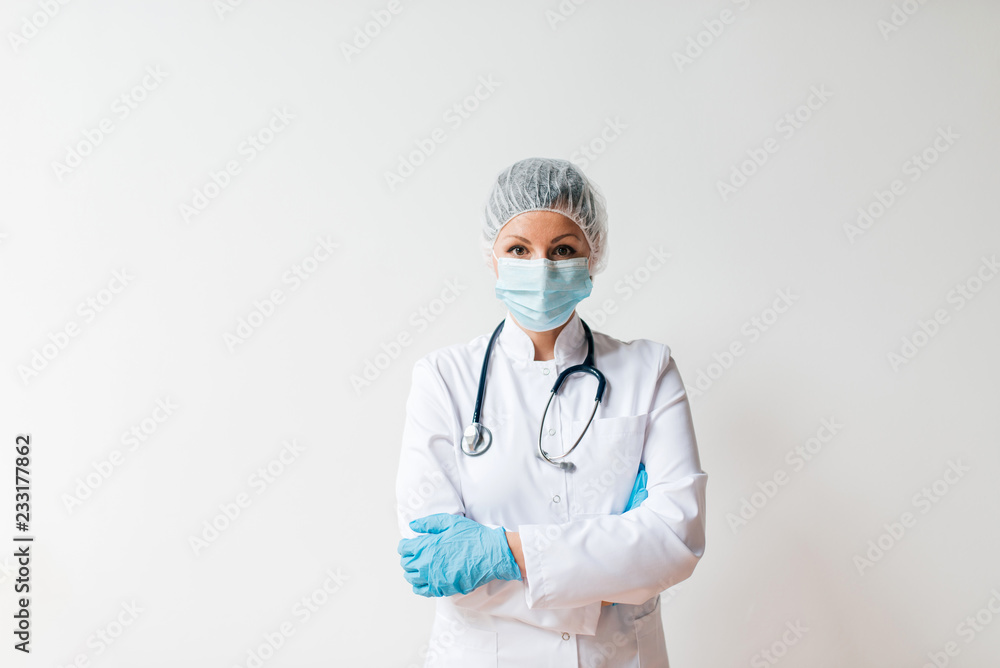 Portrait of female doctor in protective hat, mask and gloves on isolated background.