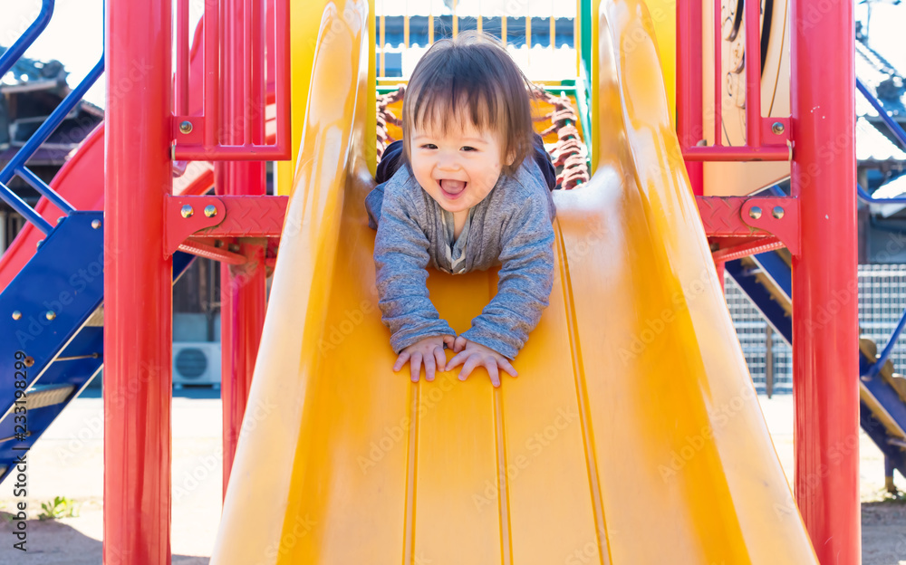 混血幼童在操场上玩滑梯