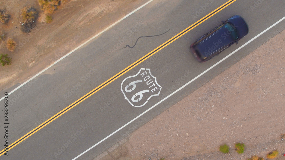 AERIAL: Black SUV car on road trip driving along the historic Route 66 in USA