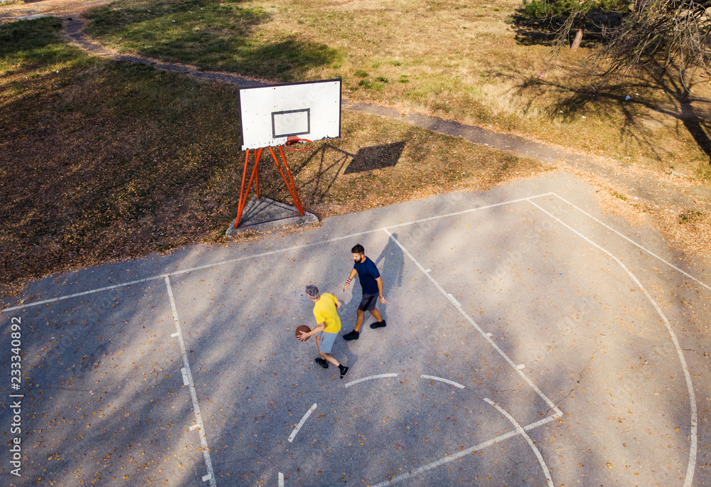 Father and son playing basketball in the park