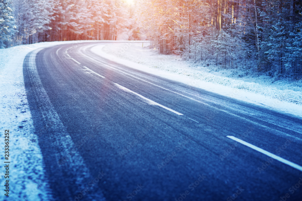 冬季道路，晴天被雪覆盖。黑色结冰沥青