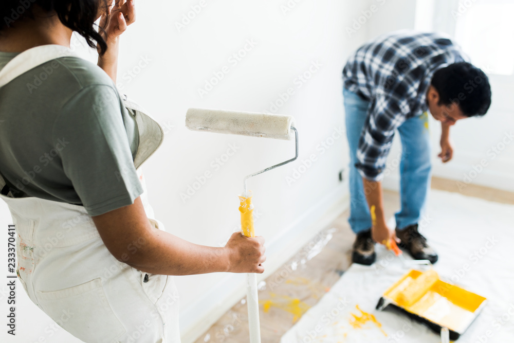 Man painting the walls yellow