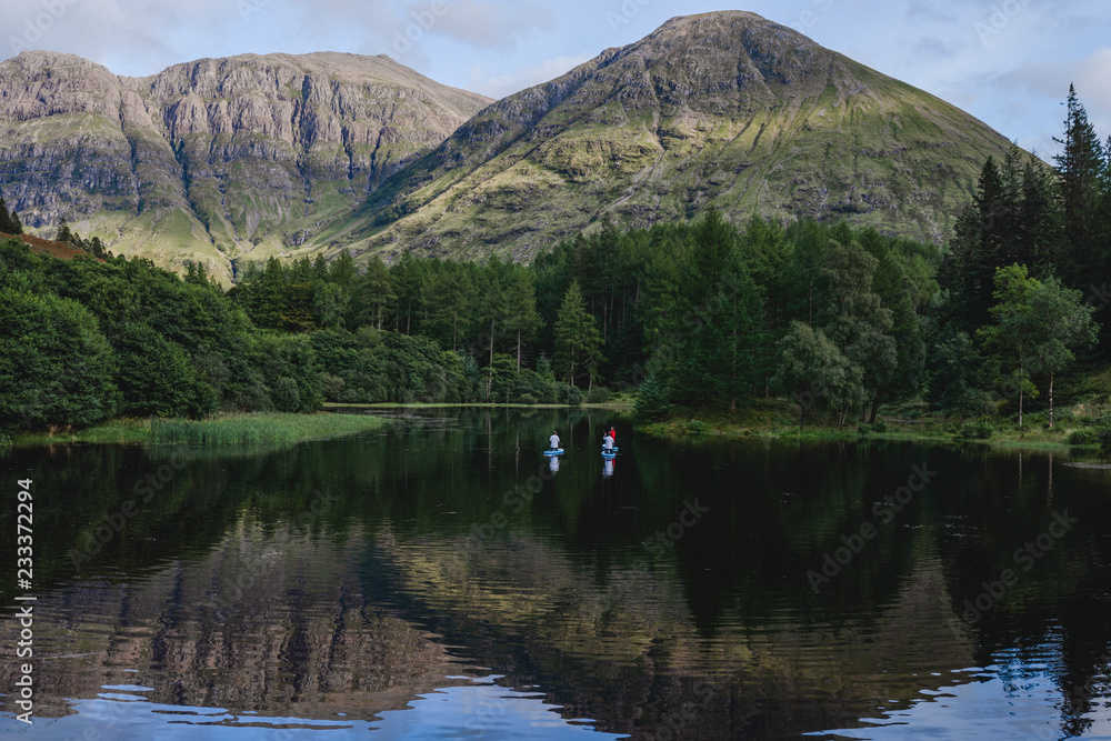 Paddle boarders on a dark lake