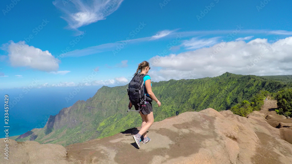 特写：活跃的年轻女子走在高高的火山山脊边缘