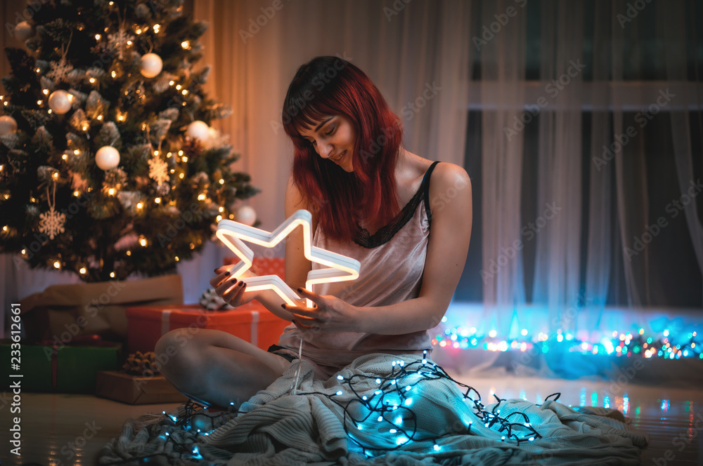 Smiling young woman with Christmas lights decoration