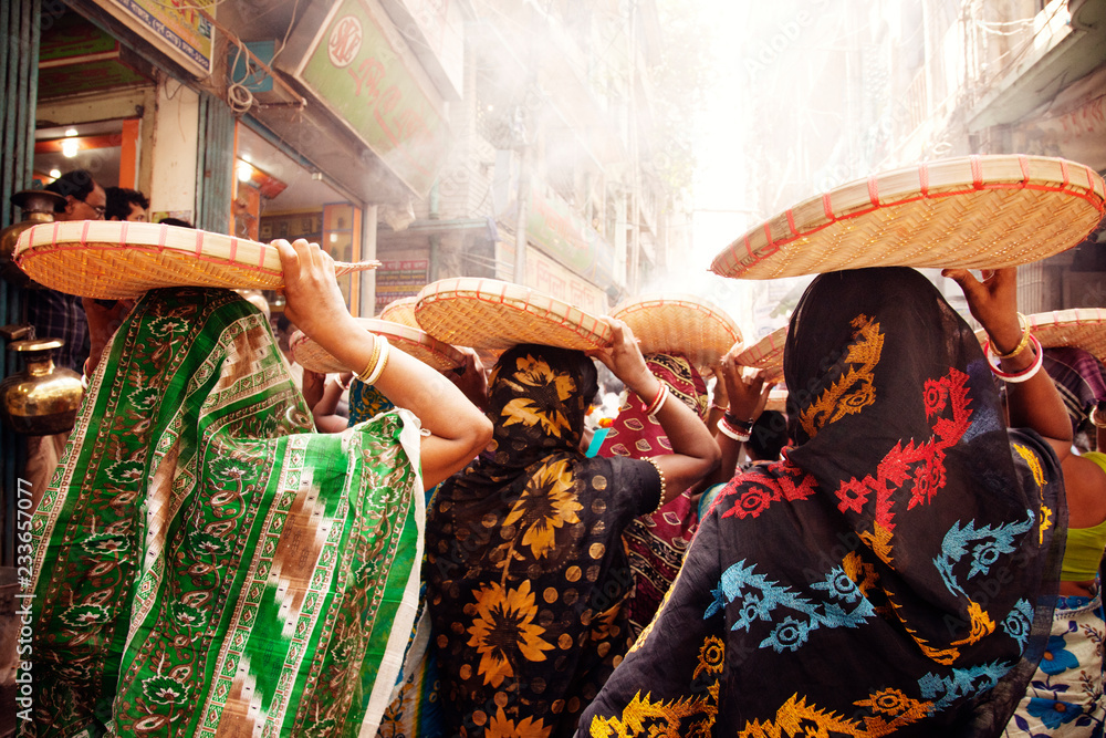 Rear view of women carrying basket on head while walking