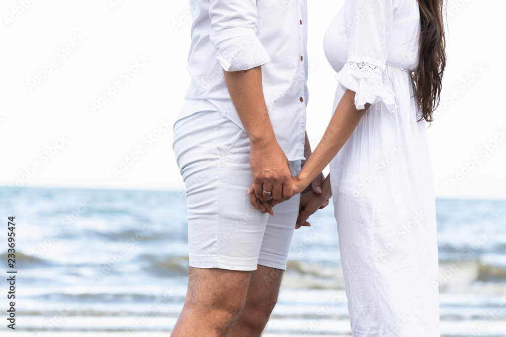 Happy couple going honeymoon travel on tropical sand beach in summer.